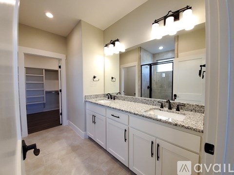 A bathroom with a vanity, sink, and mirror.