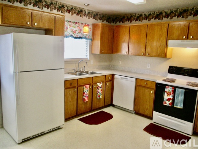 A kitchen with wooden cabinets and a white refrigerator.
