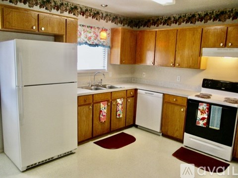 A kitchen with wooden cabinets and a white refrigerator.