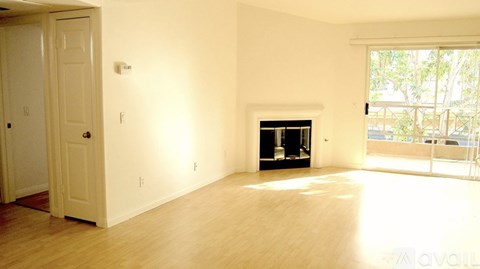 A room with a fireplace and a door on the left side.