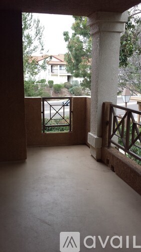 A balcony with a view of a house and trees.