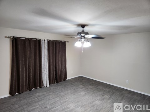 A room with a ceiling fan and a light fixture.