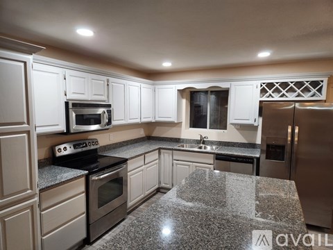 A kitchen with granite countertops and stainless steel appliances.