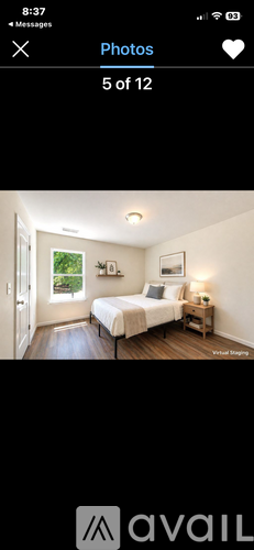 A bedroom with a bed, nightstand, and window.