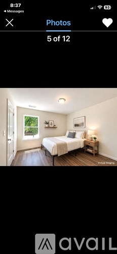 A bedroom with a bed, nightstand, and window.