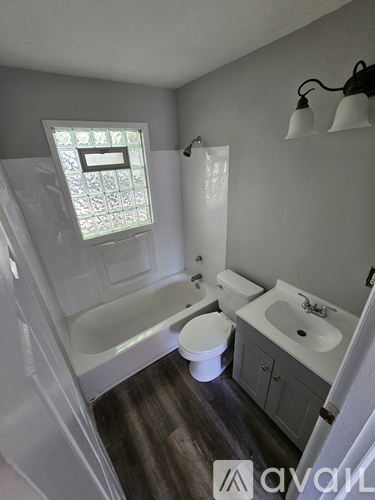 A bathroom with a toilet, sink, and bathtub.