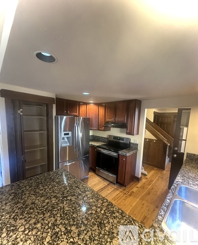A kitchen with a refrigerator, stove, and sink.