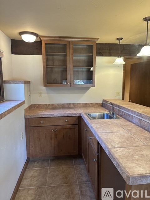 A kitchen with brown cabinets and a granite countertop.