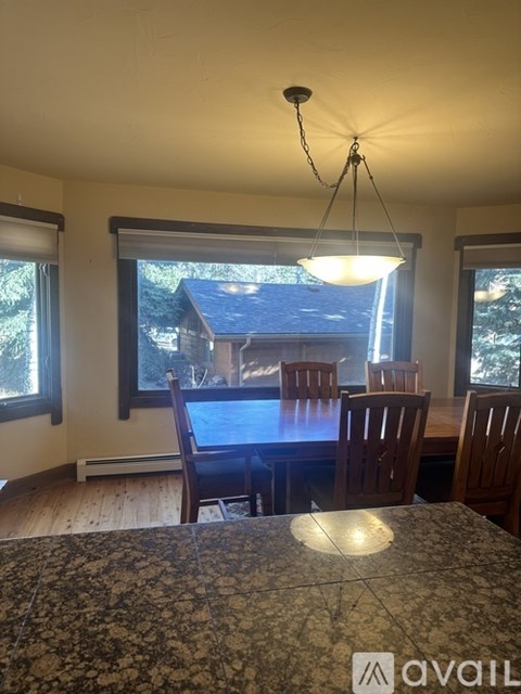 A dining room with a table and chairs.