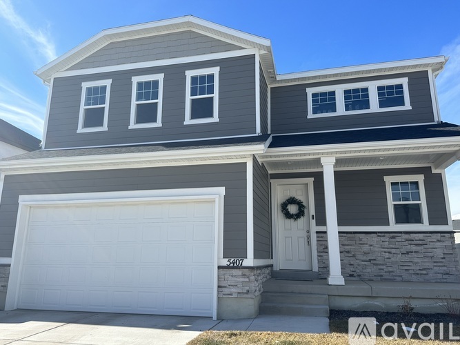 A house with a grey and white exterior and a white garage door.