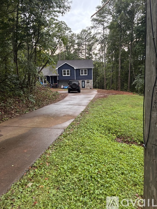 A house with a driveway and green grass in front.