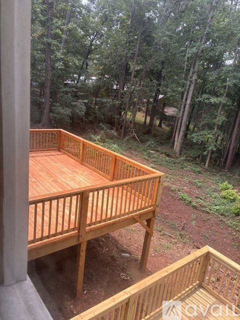A wooden deck overlooks a wooded area.