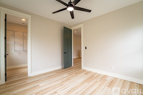 A room with a ceiling fan and wooden flooring.
