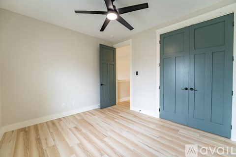 A room with a ceiling fan and wooden flooring.