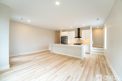 A spacious room with wooden flooring and a television on a cabinet.