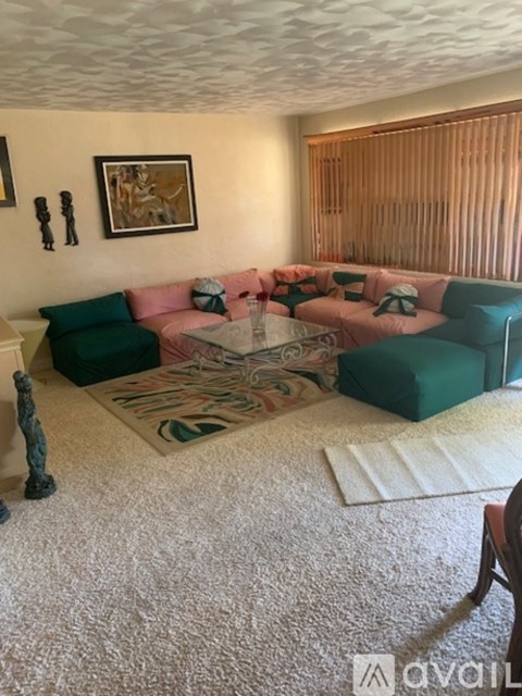 A living room with a pink couch and a green couch.