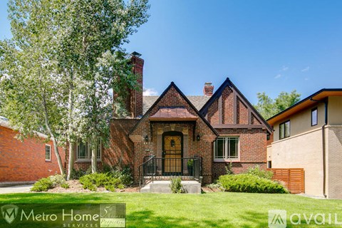 A brick house with a black iron gate in front.