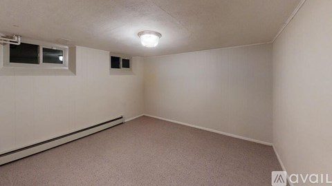 A room with a carpeted floor and a window.