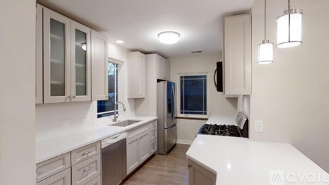A modern kitchen with white cabinets and a blue door.