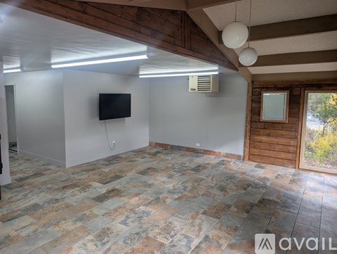 A room with a stone floor and a flat screen TV mounted on the wall.