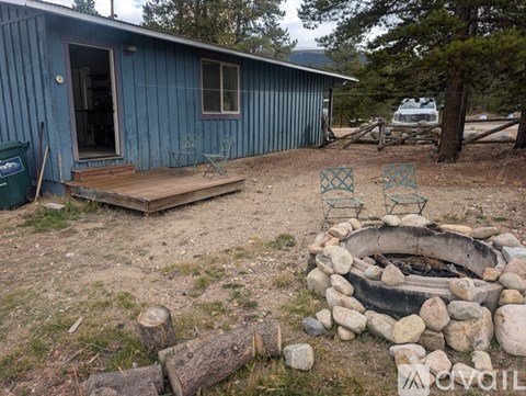 A blue house with a fire pit in front.