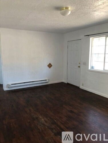 A room with wooden floors and white walls.