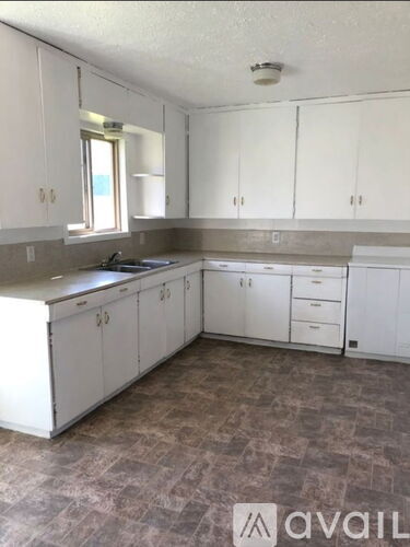 A kitchen with white cabinets and a tiled floor.