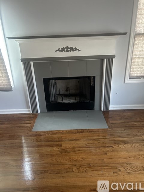 A fireplace with a wooden mantle and a white surround.