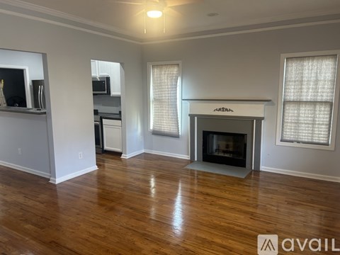 A living room with a fireplace and wooden floors.