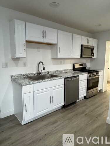 A kitchen with white cabinets and a granite countertop.