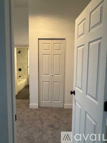 A white door is in a room with carpeting.