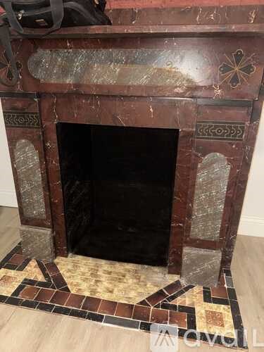 A fireplace with a black screen and a decorative tile surround.