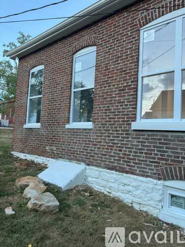 A brick house with a white window and a white baseboard.