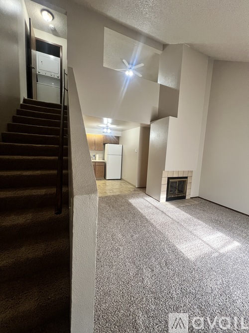 A living room with a fireplace and a staircase.