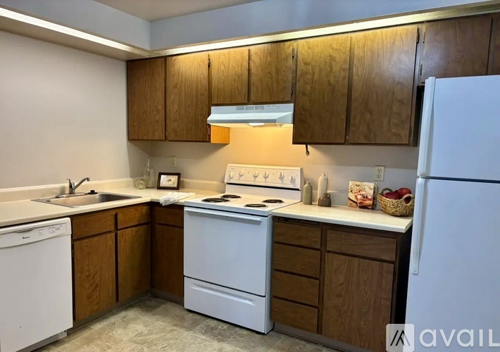 A kitchen with wooden cabinets and white appliances.