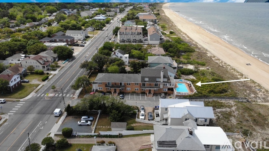 A beachfront property with a swimming pool is located near a busy road.