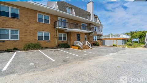A large apartment complex with a parking lot in front.