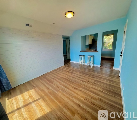 A room with wooden flooring and a white wall.