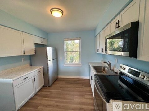 A kitchen with white cabinets and a black stove top oven.