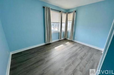 A room with a window and a view of buildings outside.