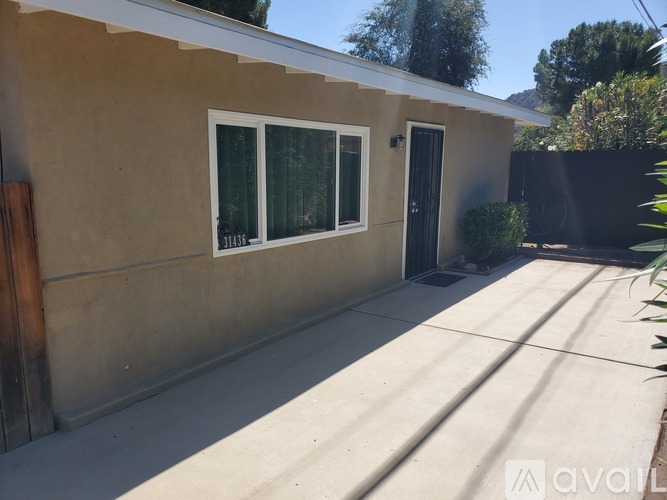 A house with a tan wall and a black door.