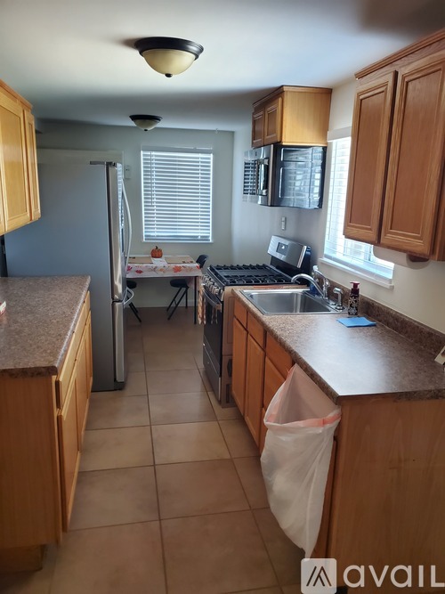 A kitchen with wooden cabinets and a granite countertop.