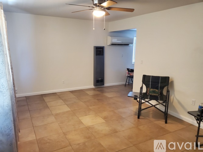 A room with a ceiling fan and a chair.
