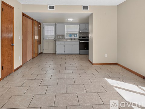 A kitchen with tile flooring and a countertop with a sink.