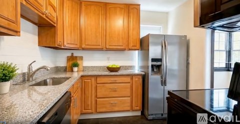 A kitchen with wooden cabinets and a granite countertop.