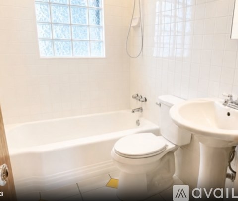 A white toilet sits next to a white sink in a bathroom.
