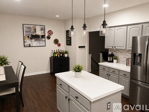 A modern kitchen with a white countertop and stainless steel appliances.