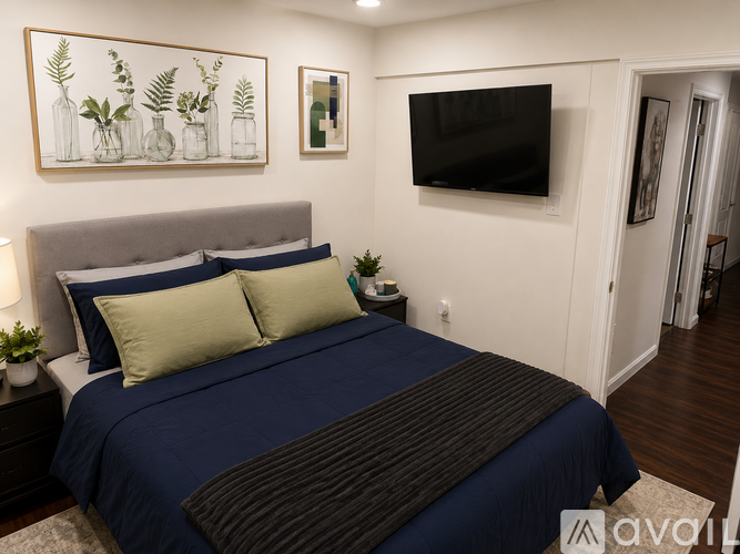 A bedroom with a large bed and a flat screen TV mounted on the wall.