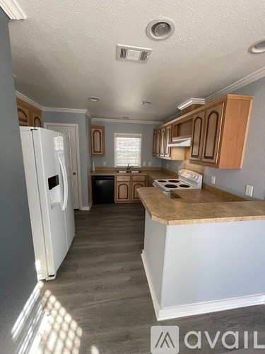A kitchen with a white refrigerator and wooden cabinets.