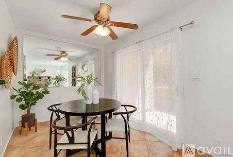 A dining room with a round table and chairs.
